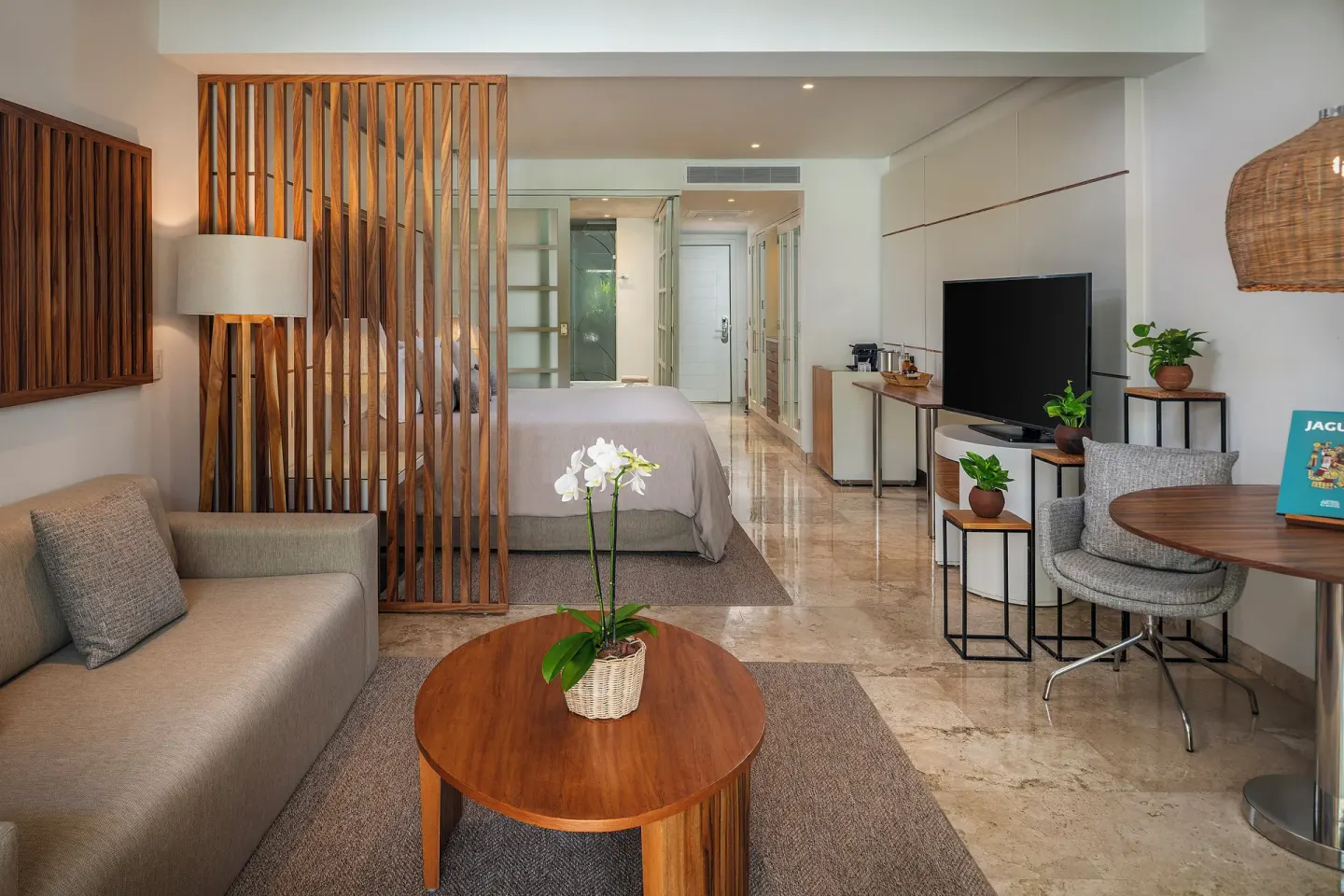 The Reserve Junior Suite Nature View living area and bed at Paradisus La Perla Riviera Maya.