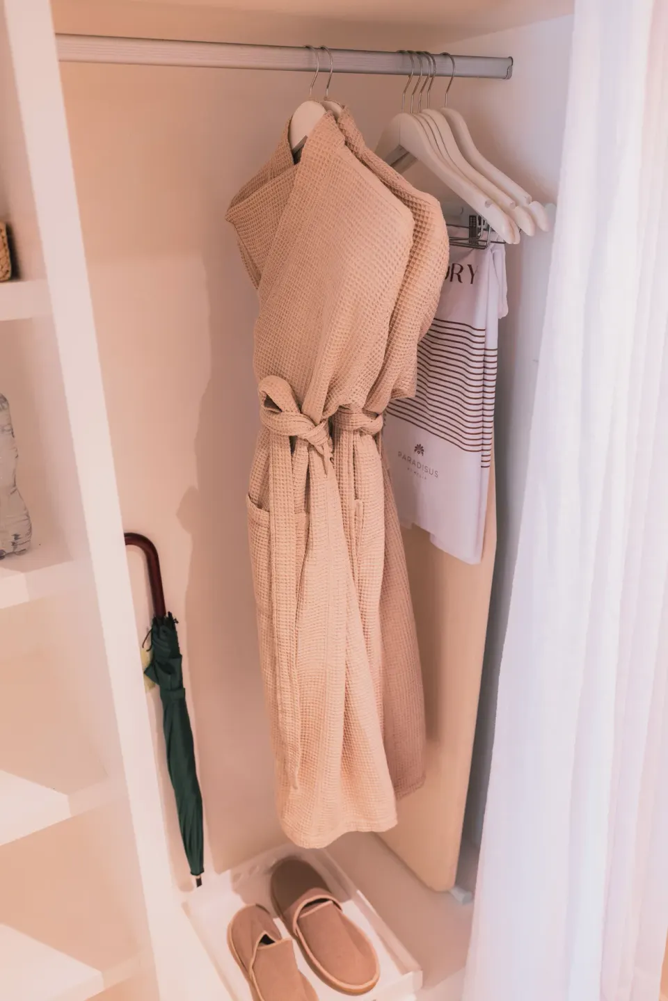 Guest closet with robe, hangers, slippers, umbrella, and beach bag at Paradisus Los Cabos.