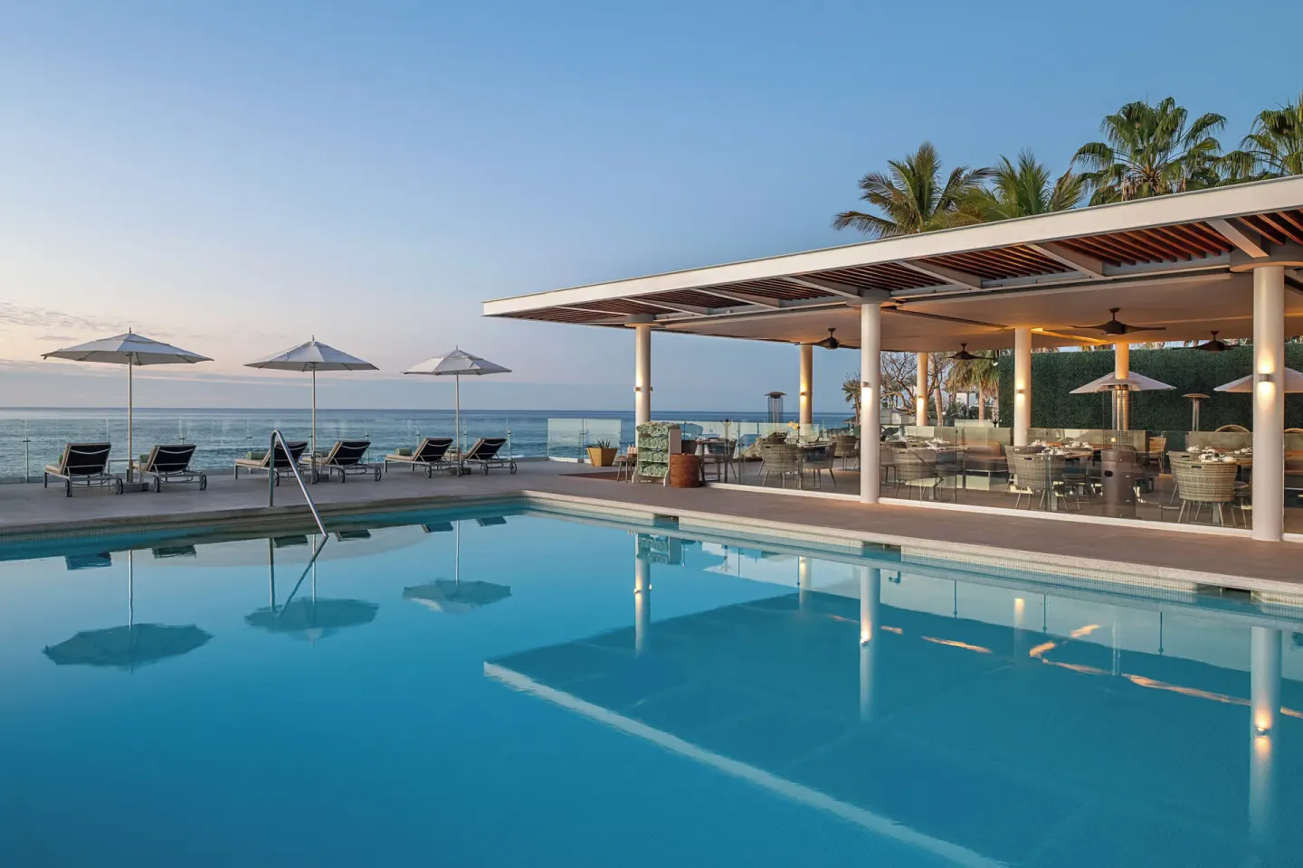 Pool beside an open-air terrace and ocean at Paradisus Los Cabos.