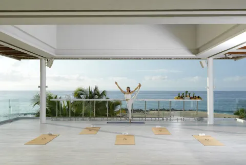 Yoga instructor on an oceanfront terrace at Paradisus Los Cabos.