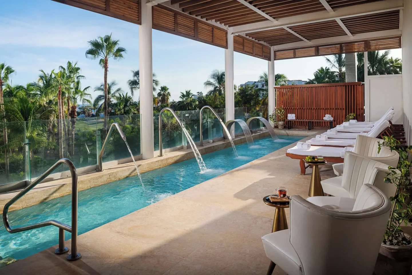 Spa hydrotherapy pool with loungers and palm views at Paradisus Los Cabos.