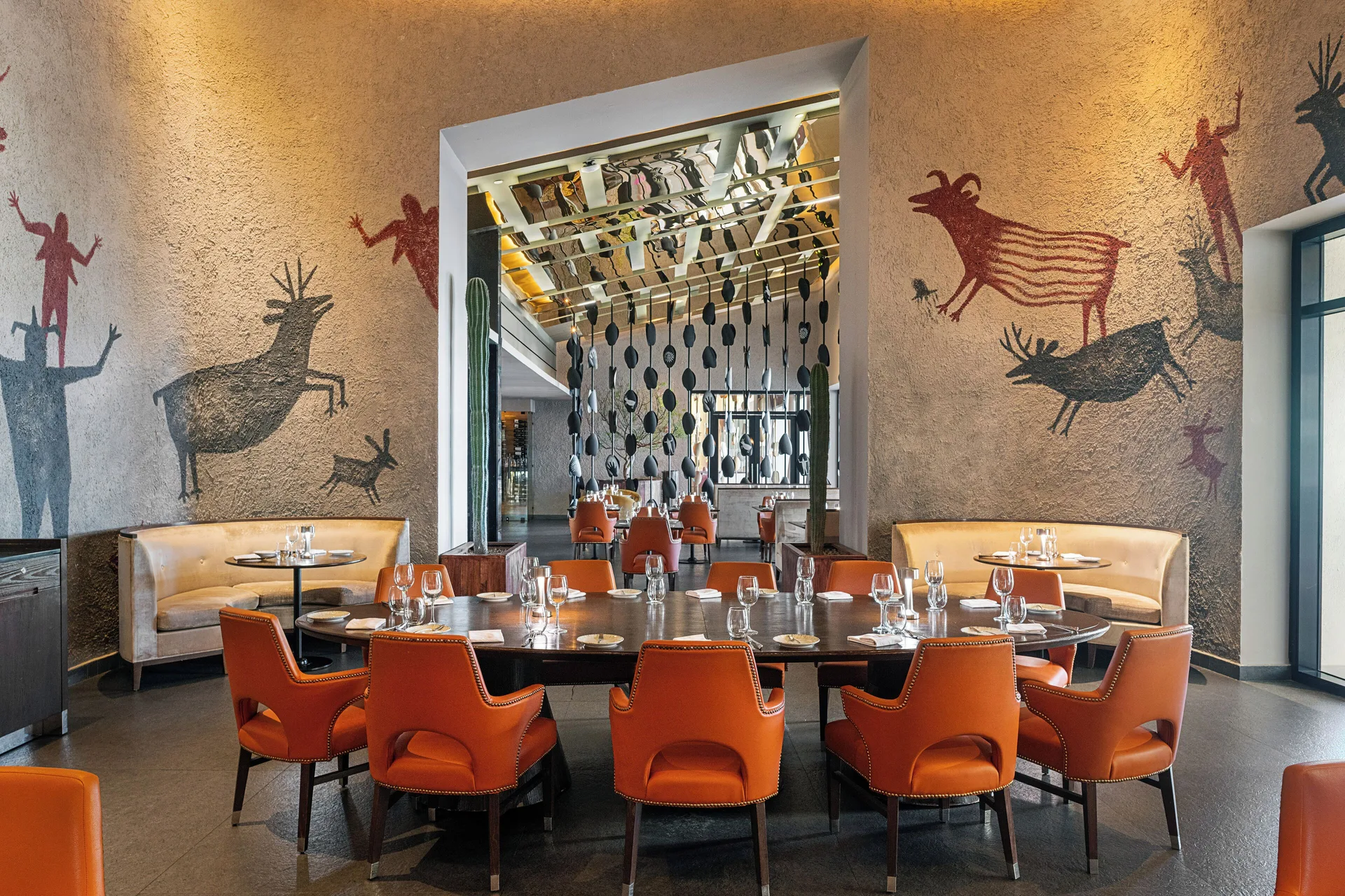 Restaurant dining room with cave-style animal murals at Paradisus Los Cabos.