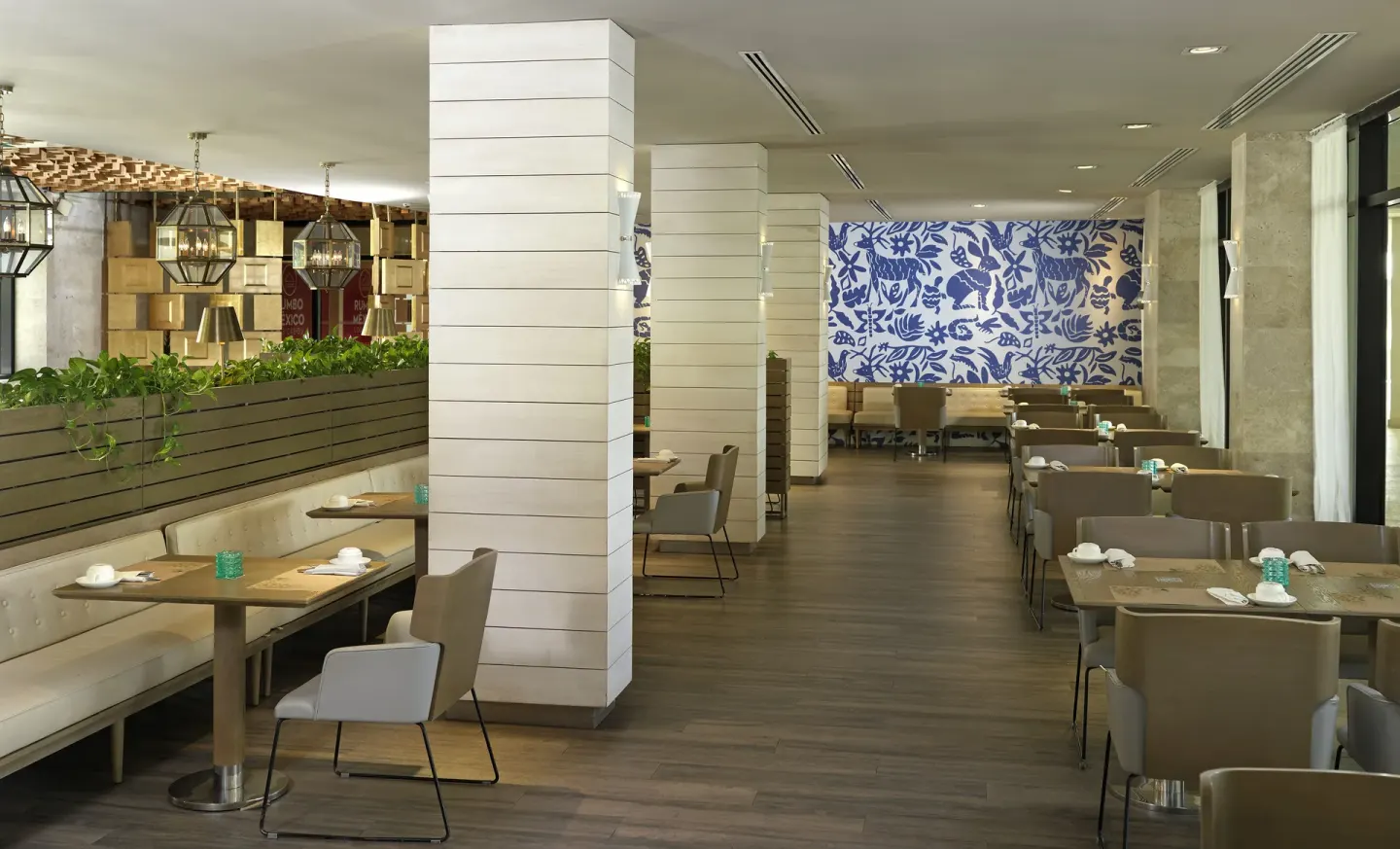 Dining room with tables, white columns, and blue patterned wall at Paradisus Los Cabos.