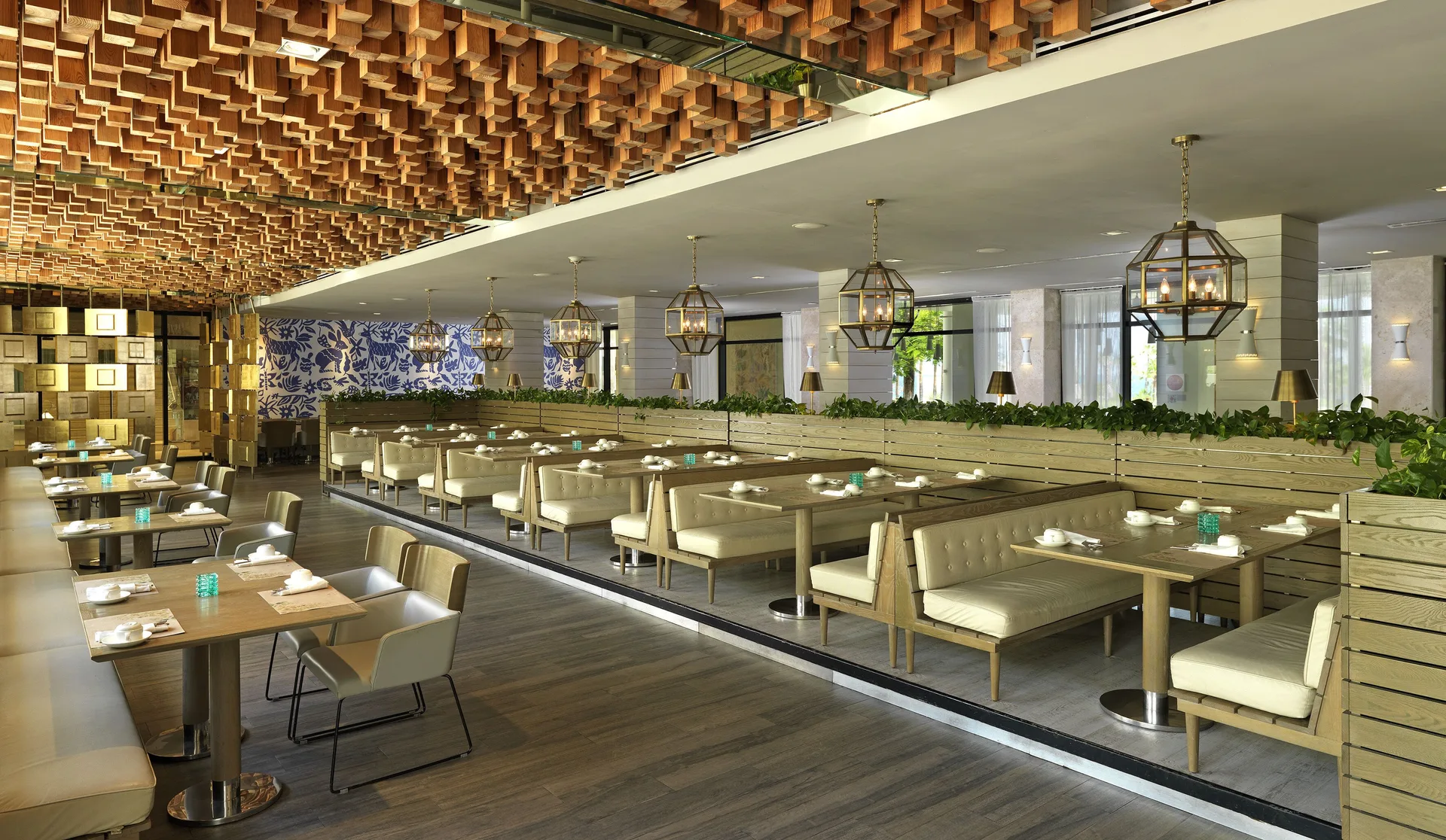 Restaurant dining room with booths and geometric ceiling detail at Paradisus Los Cabos.