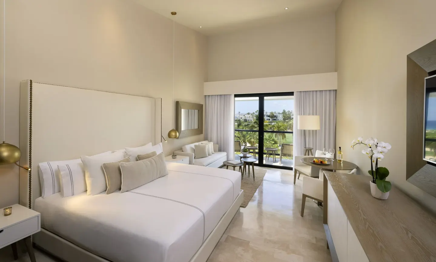 King-bed Junior Suite with sofa, balcony, and garden view at Paradisus Los Cabos.
