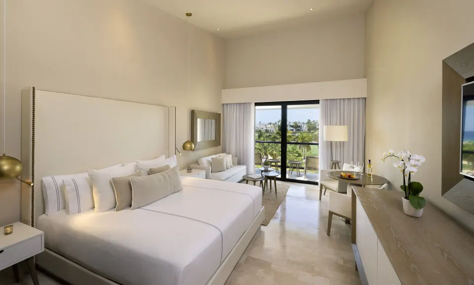 King-bed Junior Suite with sofa, balcony, and garden view at Paradisus Los Cabos.