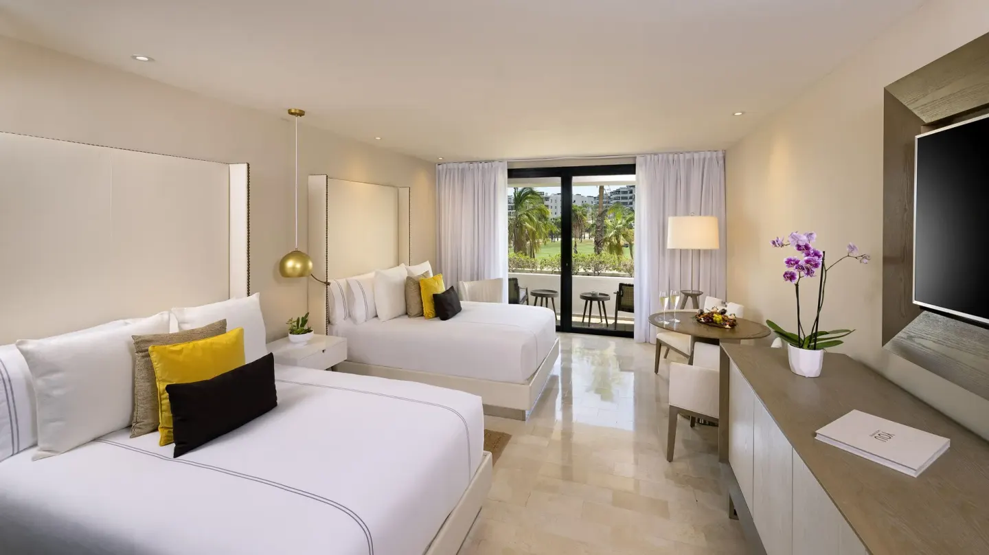 Junior Suite with two beds, balcony, desk, and garden view at Paradisus Los Cabos.