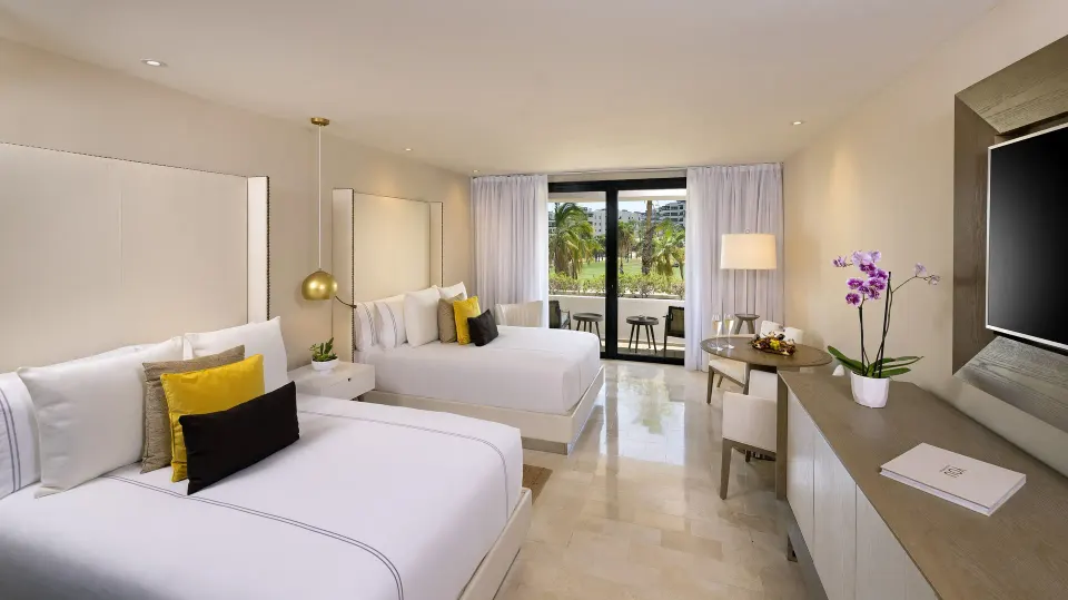 Junior Suite with two beds, balcony, desk, and garden view at Paradisus Los Cabos.