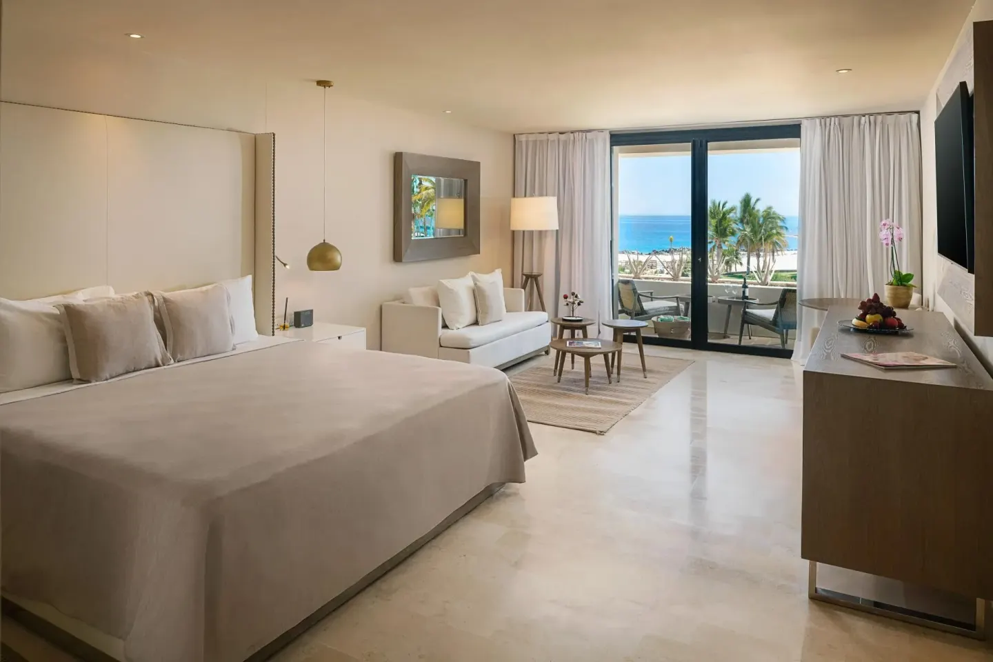 Junior Suite Ocean View with king bed, sofa, TV, and ocean-facing balcony at Paradisus Los Cabos.