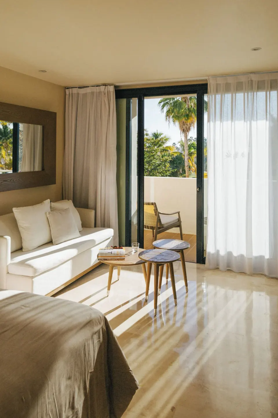 Junior Suite Ocean View sofa, tables, and balcony doors at Paradisus Los Cabos.