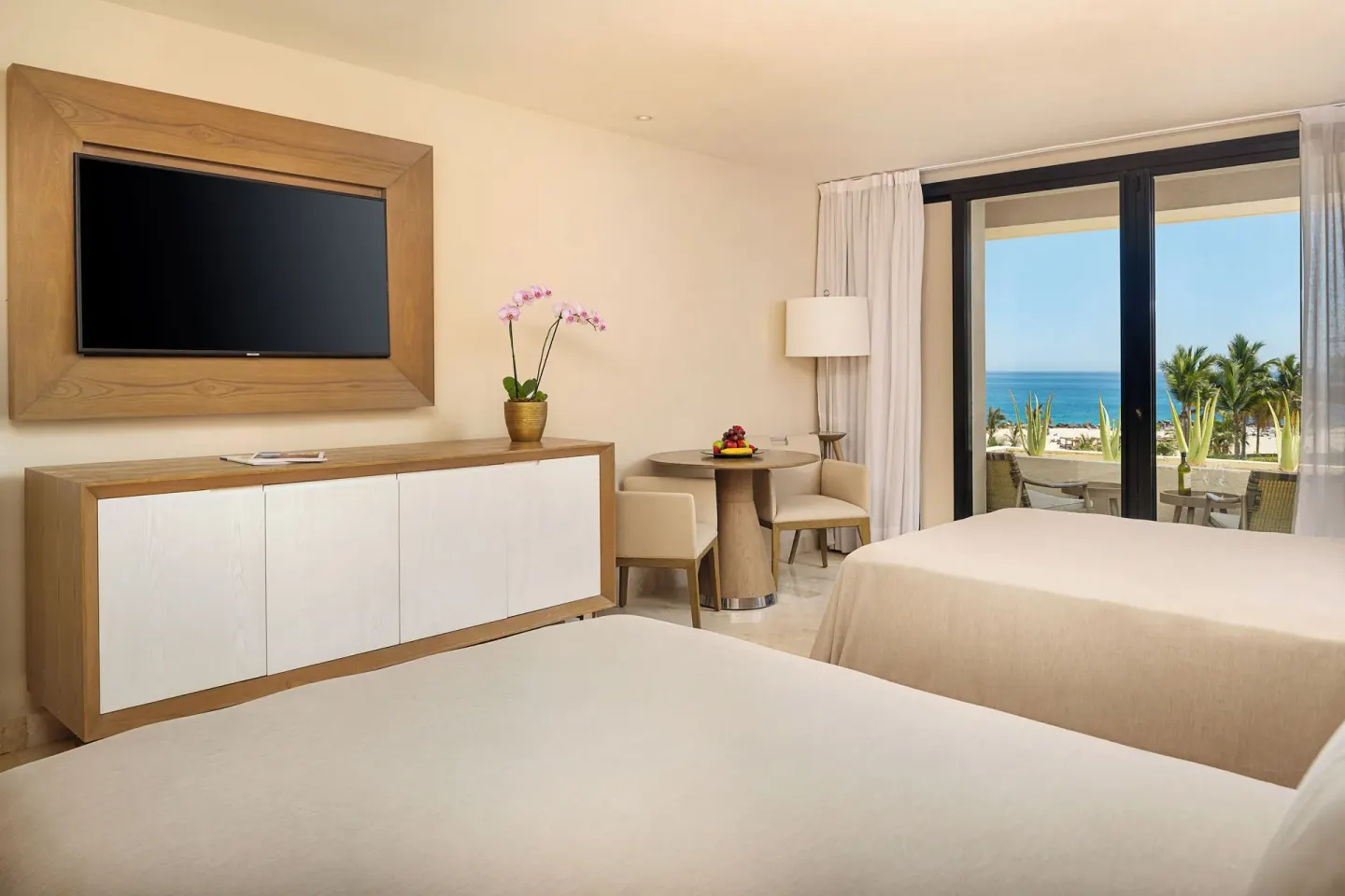 Junior Suite Ocean View with two beds, TV, dining nook, and balcony at Paradisus Los Cabos.