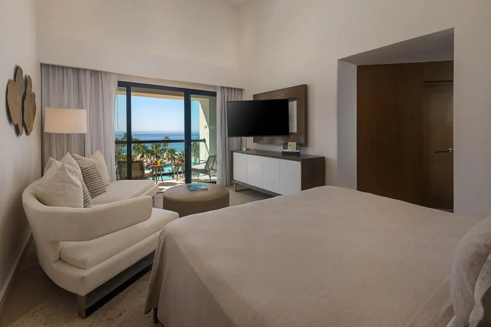 The Reserve Master Suite king bed at Paradisus Los Cabos with sofa, TV, balcony doors, and ocean view.