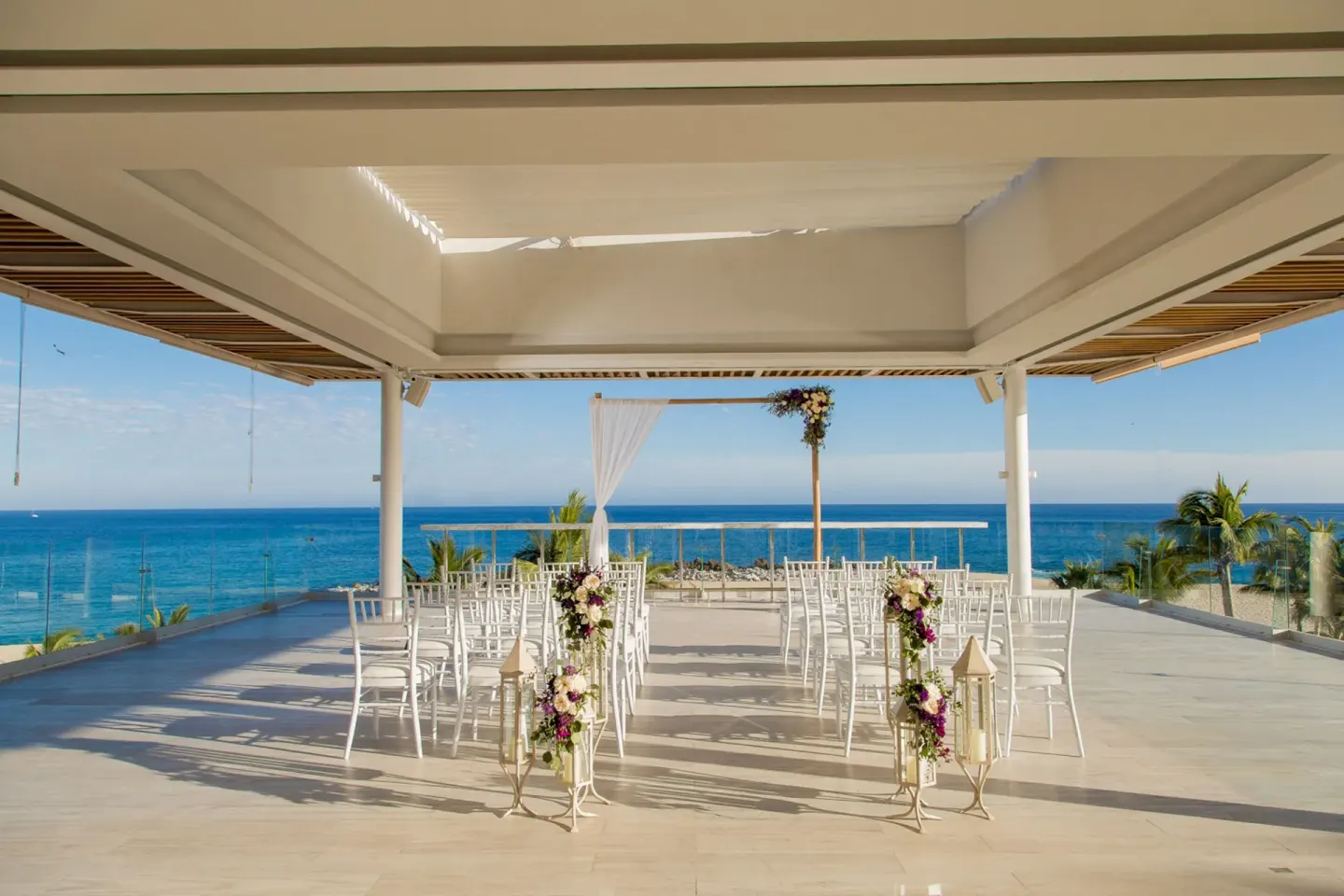 Oceanfront terrace wedding setup with white chairs at Paradisus Los Cabos.