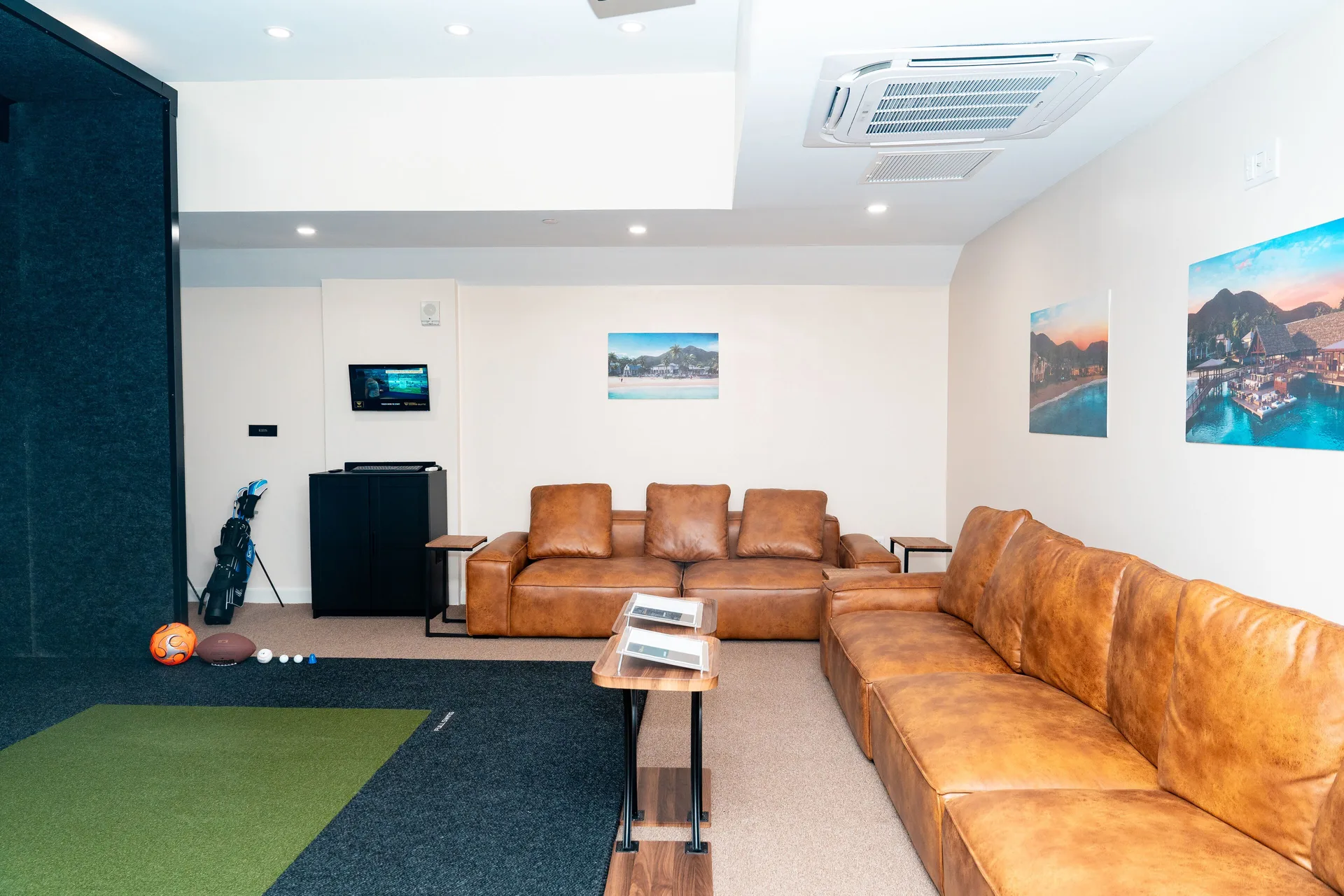 Indoor golf simulator lounge with leather sofas at Park Hyatt St. Kitts.