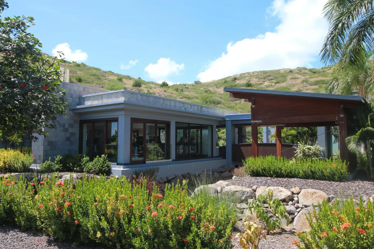 Low resort building and landscaped gardens below a hillside at Park Hyatt St. Kitts.