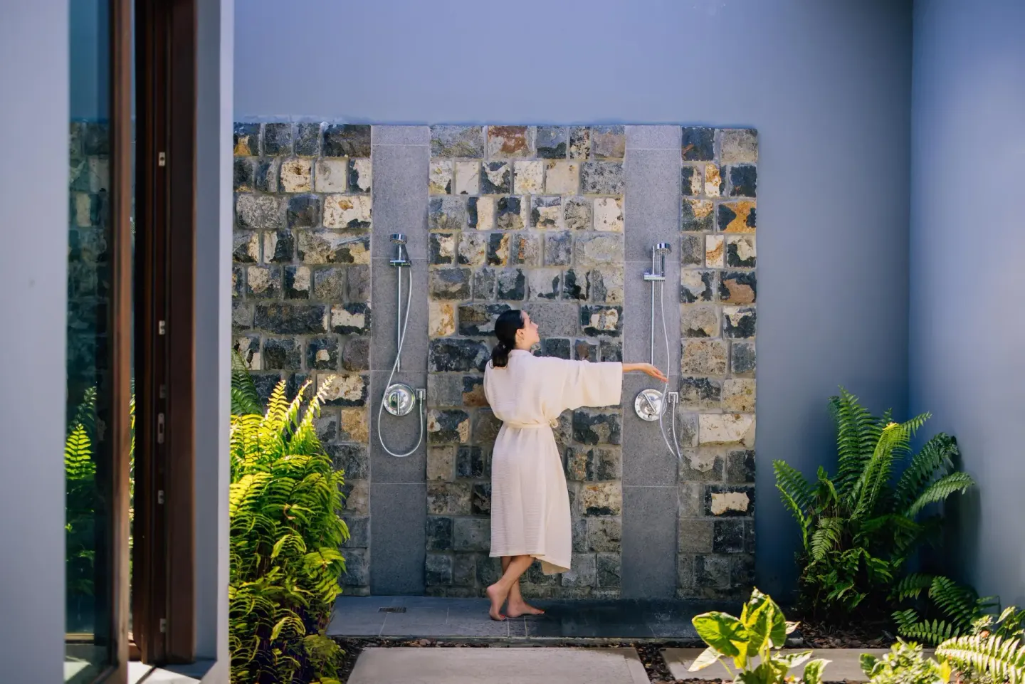 Outdoor shower area with stone wall and tropical plants at Park Hyatt St. Kitts.