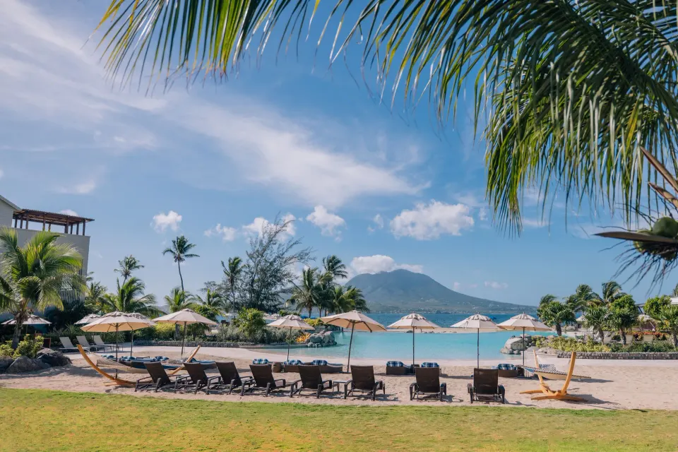 Pool loungers and umbrellas face the sea and mountains at Park Hyatt St. Kitts.