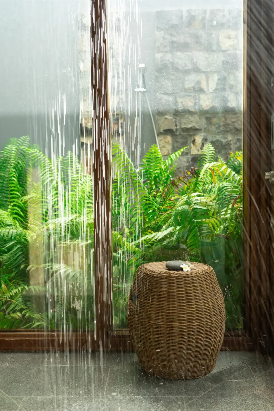 Indoor rain shower beside ferns and a stone wall at Park Hyatt St. Kitts.