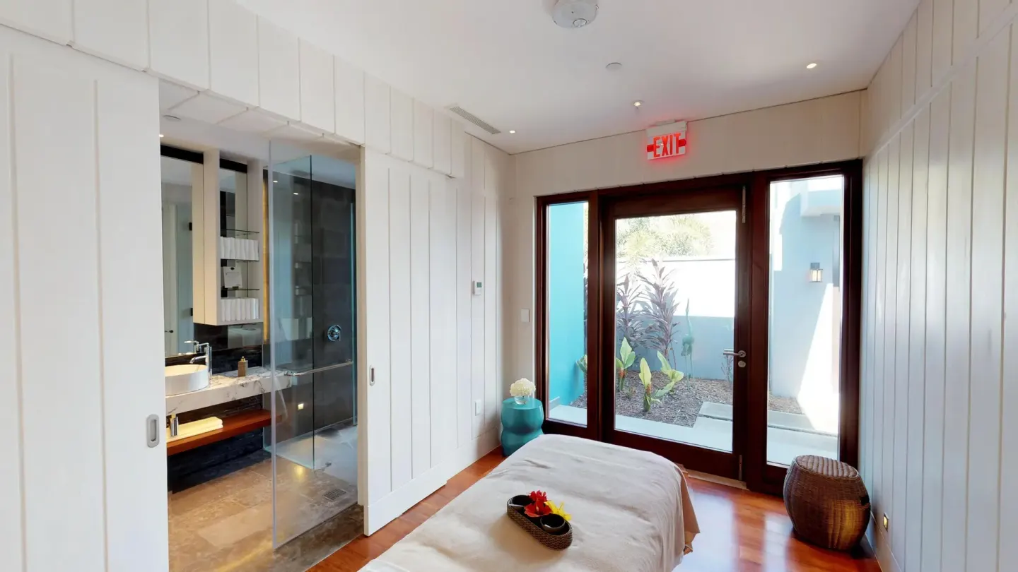 Spa treatment room with massage table and glass doors at Park Hyatt St. Kitts.