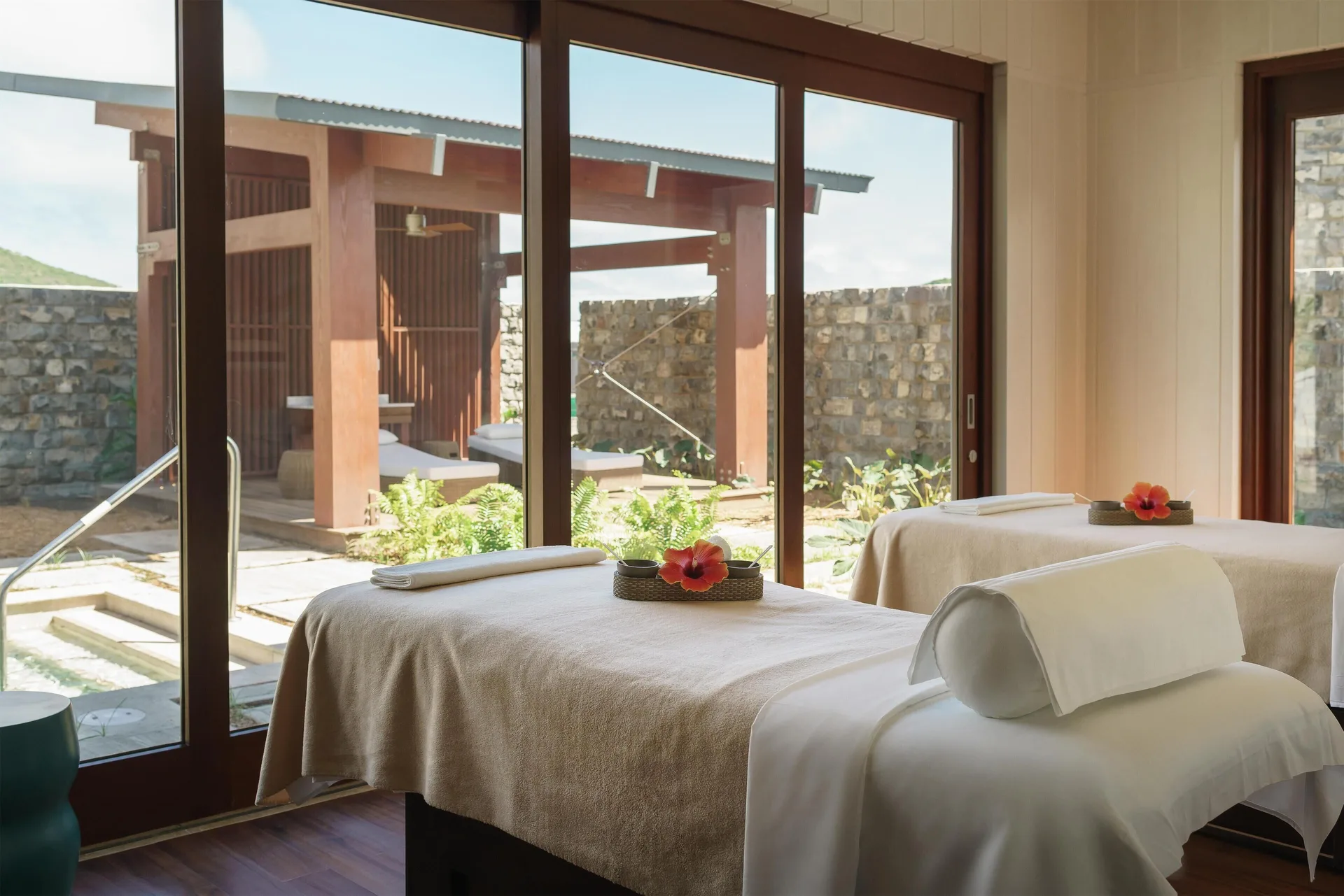 Spa treatment room with two massage tables and garden views at Park Hyatt St. Kitts.