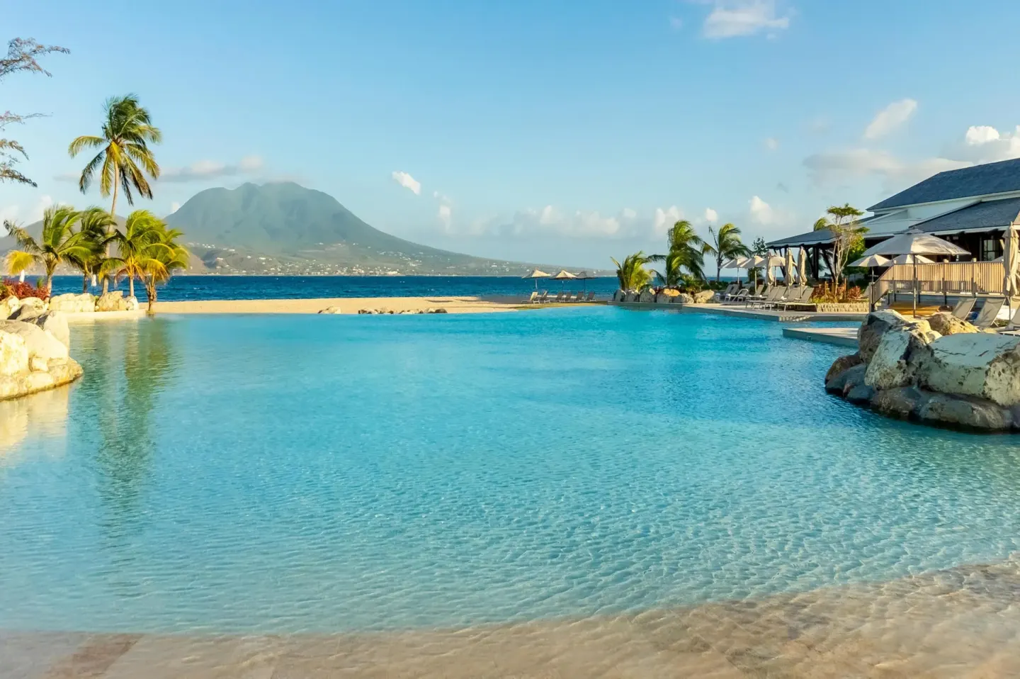 Wide turquoise pool with beach and mountain views at Park Hyatt St. Kitts.