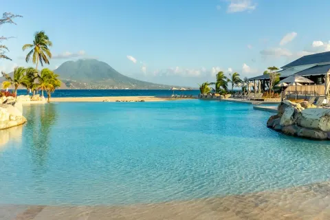 Wide turquoise pool with beach and mountain views at Park Hyatt St. Kitts.