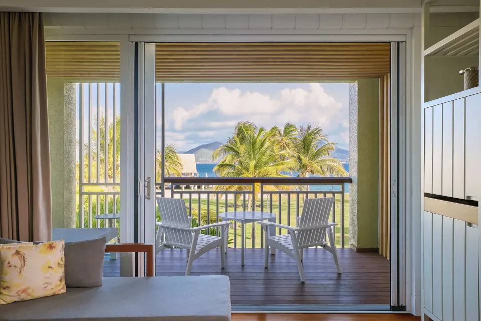 Ocean View room balcony at Park Hyatt St. Kitts with white chairs, palms, and water in view.