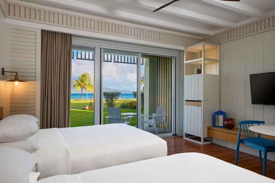 Two beds in an Ocean View room at Park Hyatt St. Kitts with patio seating and sea beyond.