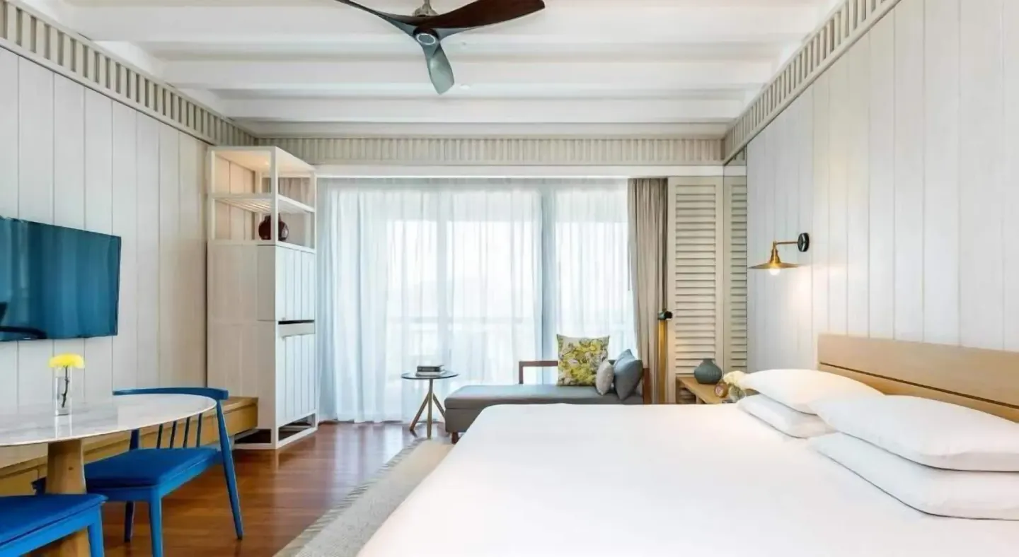 King bed guest room with desk, seating area, and sheer balcony curtains at Park Hyatt St. Kitts.