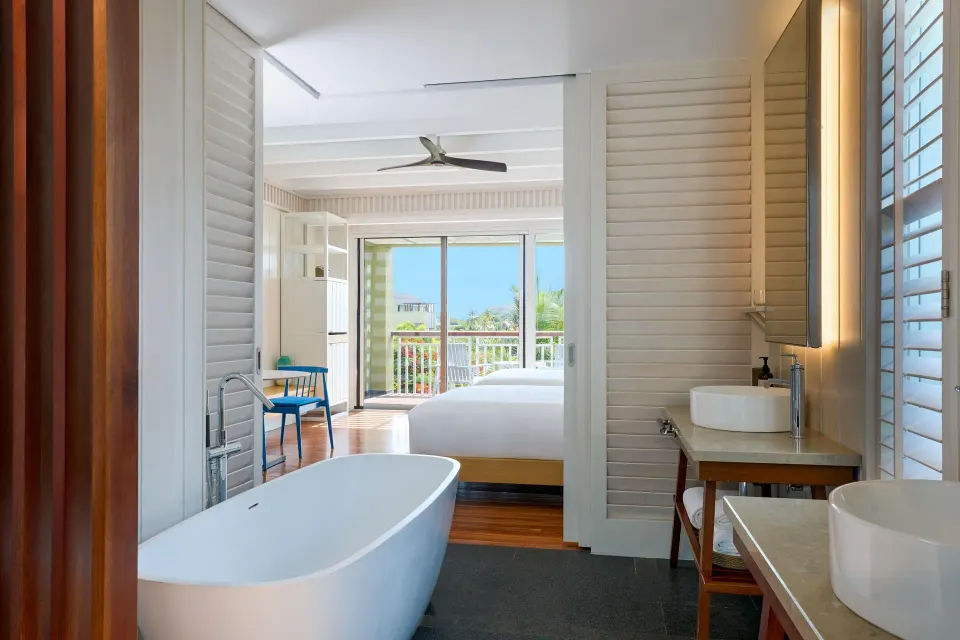 Guest room bathroom with freestanding tub and bedroom beyond at Park Hyatt St. Kitts.
