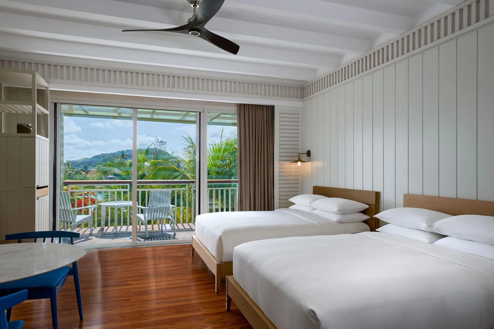 Two-bed guest room with balcony seating and island views at Park Hyatt St. Kitts.