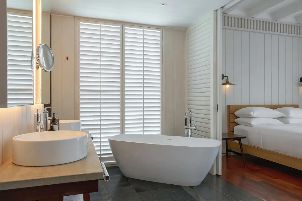 Suite bathroom with soaking tub, vanity and king bedroom beyond at Park Hyatt St. Kitts.