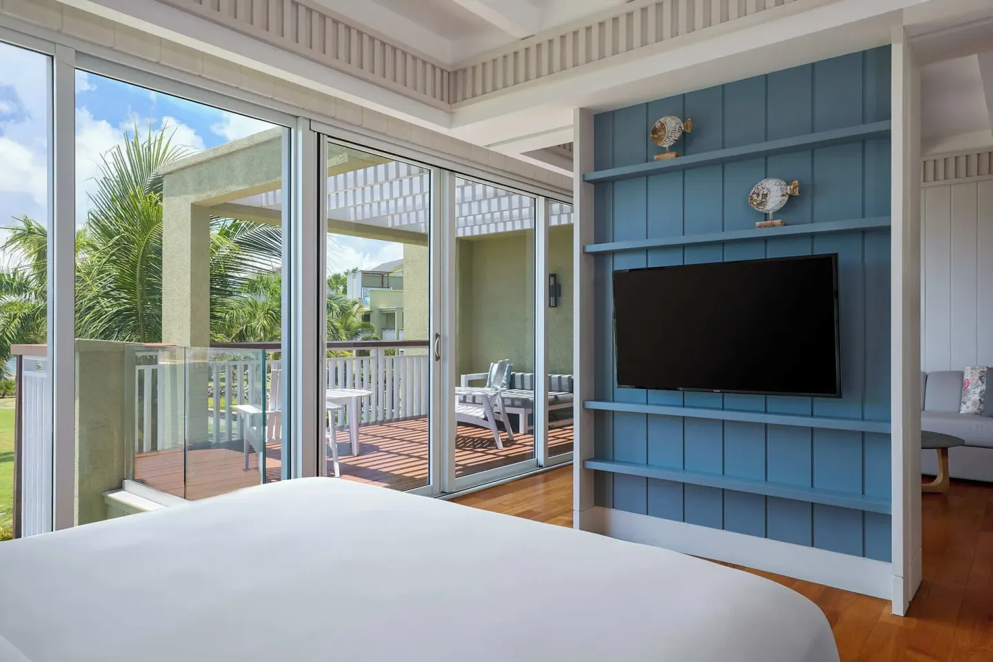 Suite bedroom with king bed, blue TV wall and balcony at Park Hyatt St. Kitts.