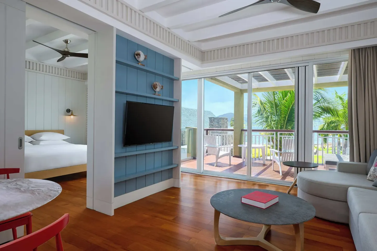 Suite living area with bedroom, balcony and ocean glimpse at Park Hyatt St. Kitts.