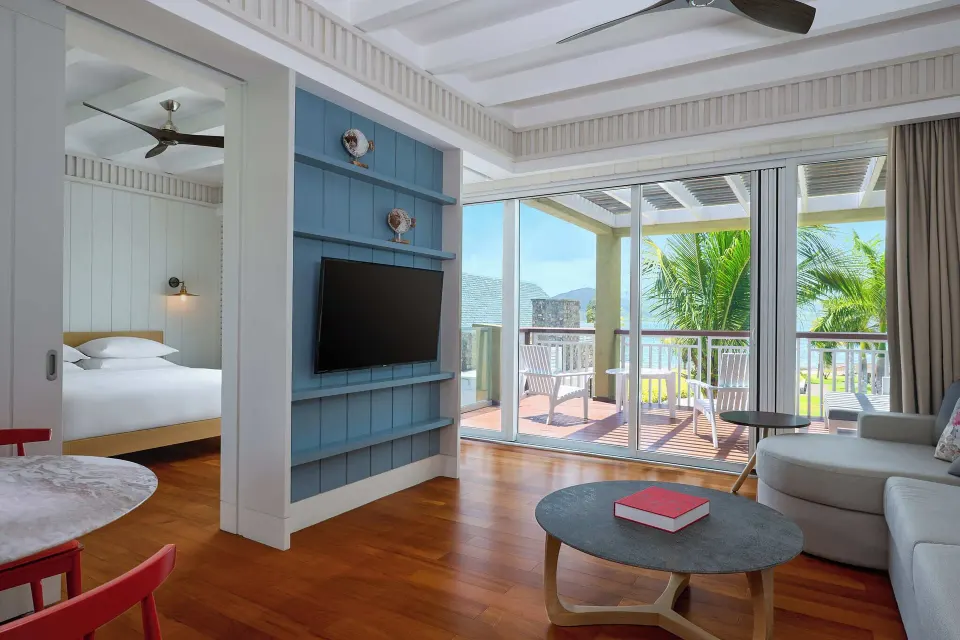 Suite living area with bedroom, balcony and ocean glimpse at Park Hyatt St. Kitts.