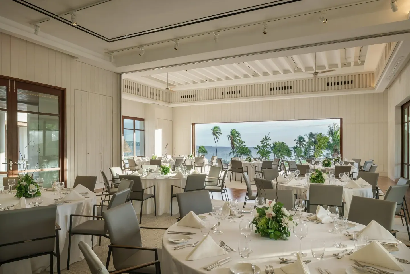 Banquet dining room set with round tables and ocean view at Park Hyatt St. Kitts.