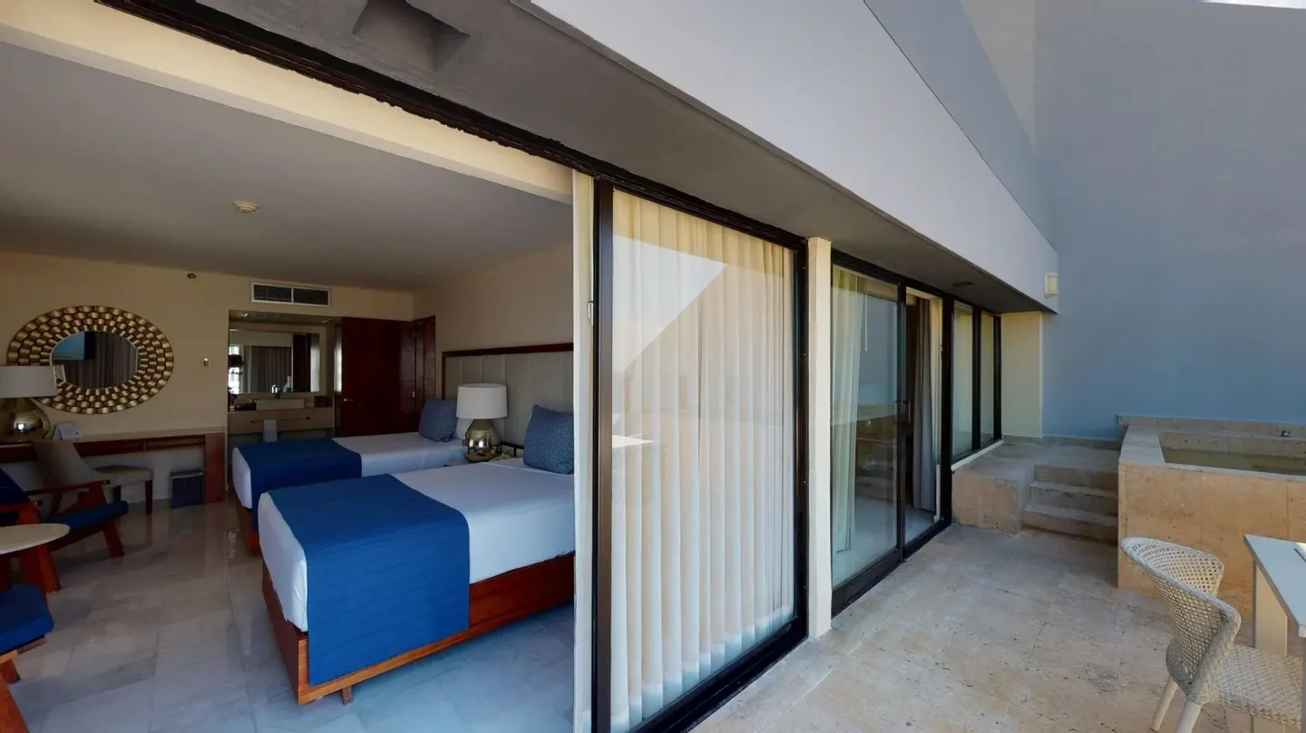 Guest room with two beds opening to a terrace at Park Royal Beach Cancun.