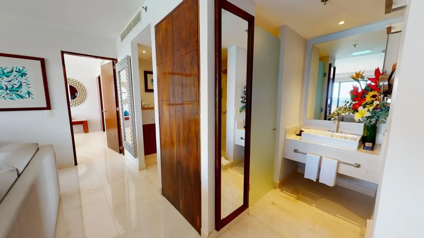 Guest suite hallway with bathroom vanity and living area at Park Royal Beach Cancun.