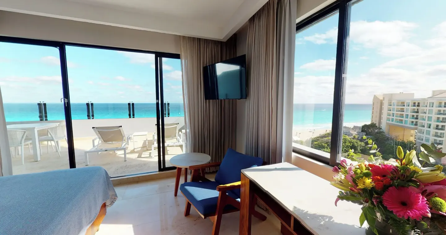 Guest room seating area with ocean-view terrace at Park Royal Beach Cancun.