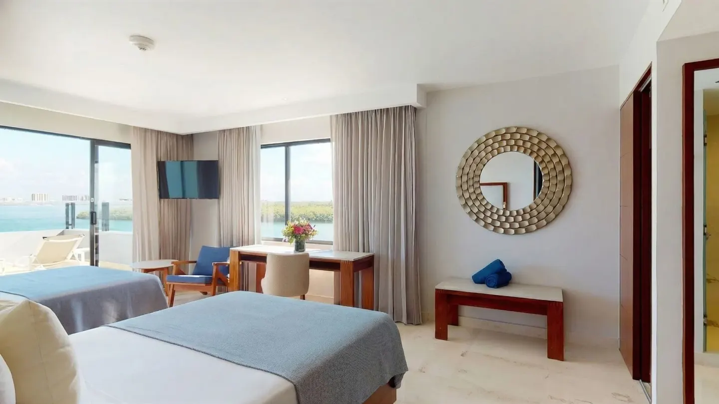 Ocean view guest room with two beds and desk at Park Royal Beach Cancun.