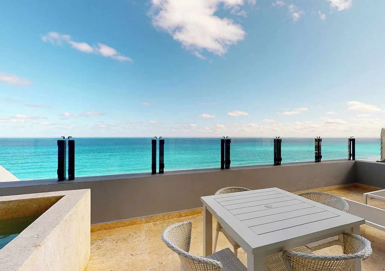 Ocean-view terrace with table, chairs, and plunge pool at Park Royal Beach Cancun.