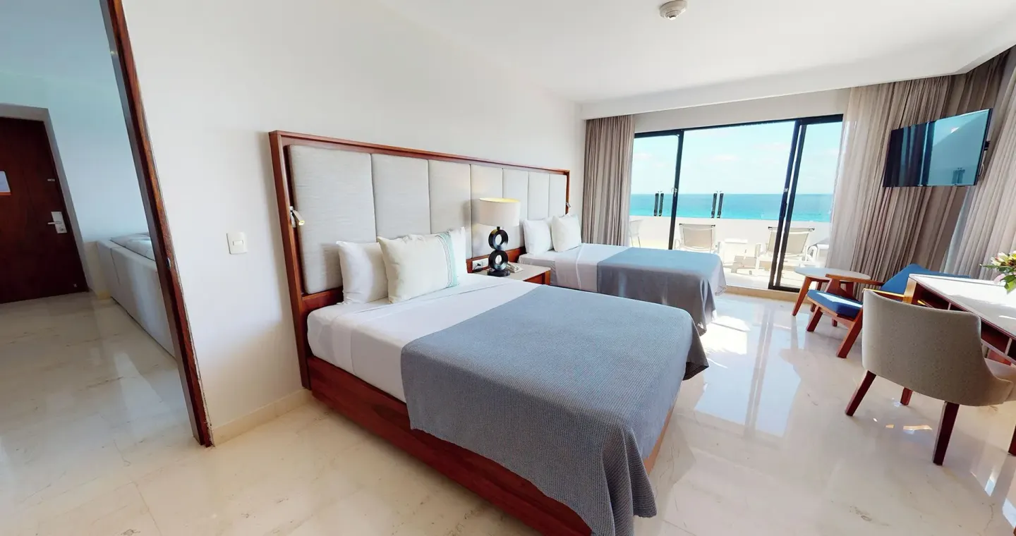 Two-bed oceanfront guest room with balcony at Park Royal Beach Cancun.