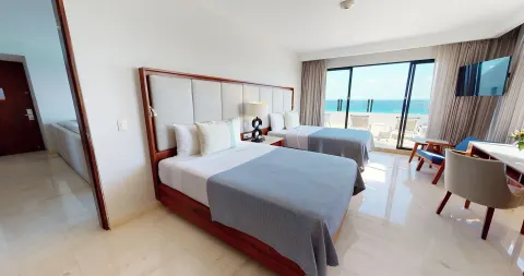 Two-bed oceanfront guest room with balcony at Park Royal Beach Cancun.