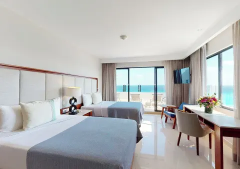 Oceanfront guest room with two beds and balcony at Park Royal Beach Cancun.