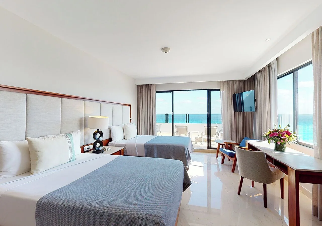 Oceanfront guest room with two beds and balcony at Park Royal Beach Cancun.