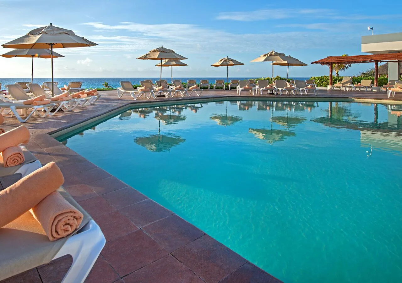 Oceanfront pool with loungers and umbrellas at Park Royal Beach Cancun.