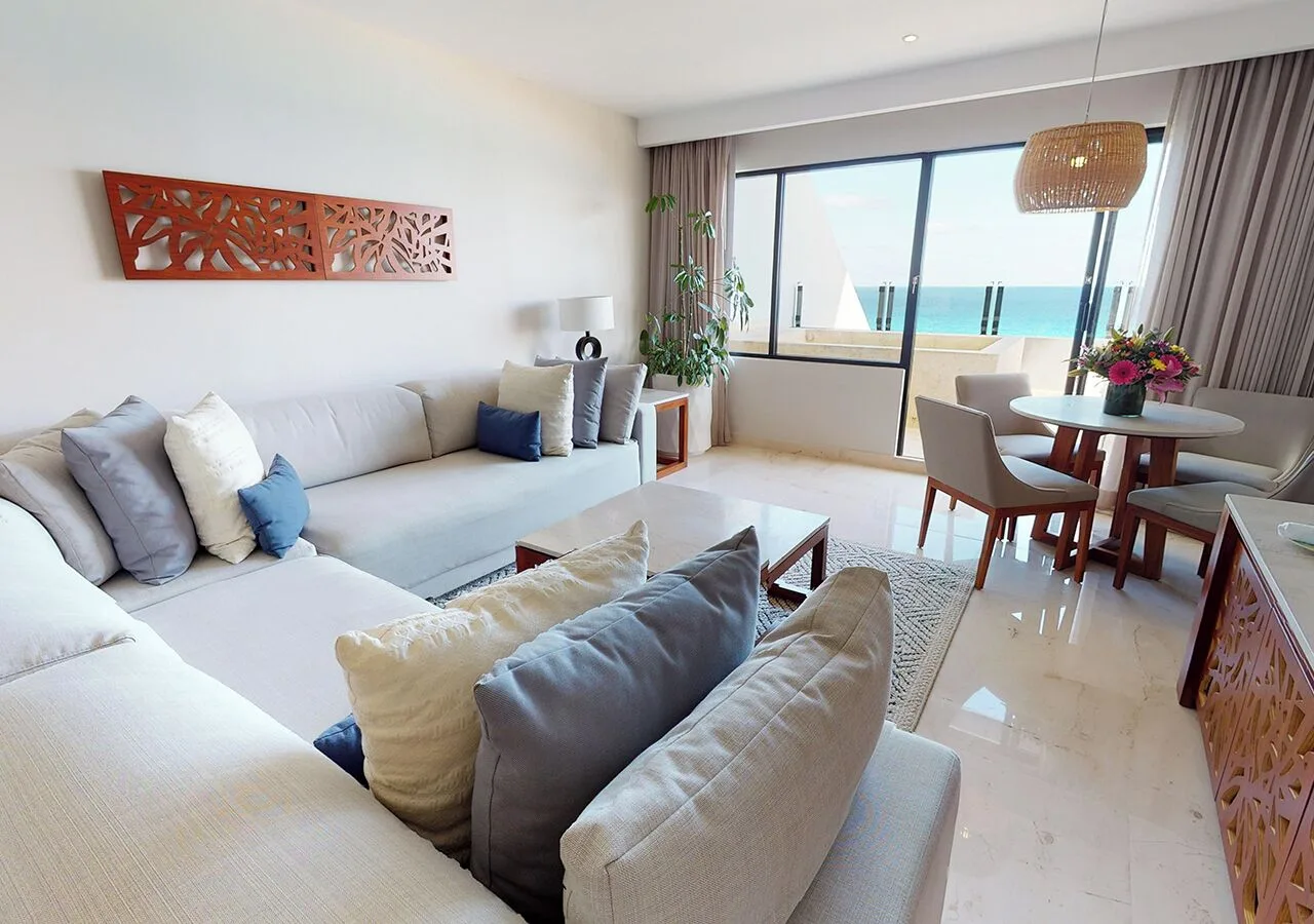 Ocean-facing suite living room with balcony doors at Park Royal Beach Cancun.