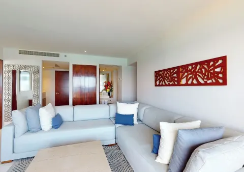 Sectional seating and hallway doors in a suite living room at Park Royal Beach Cancun.