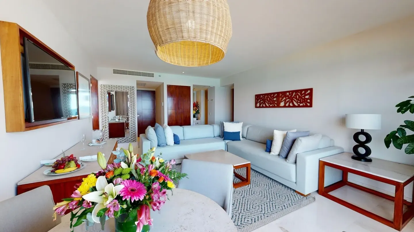Wide suite living room with TV console and sectional sofa at Park Royal Beach Cancun.