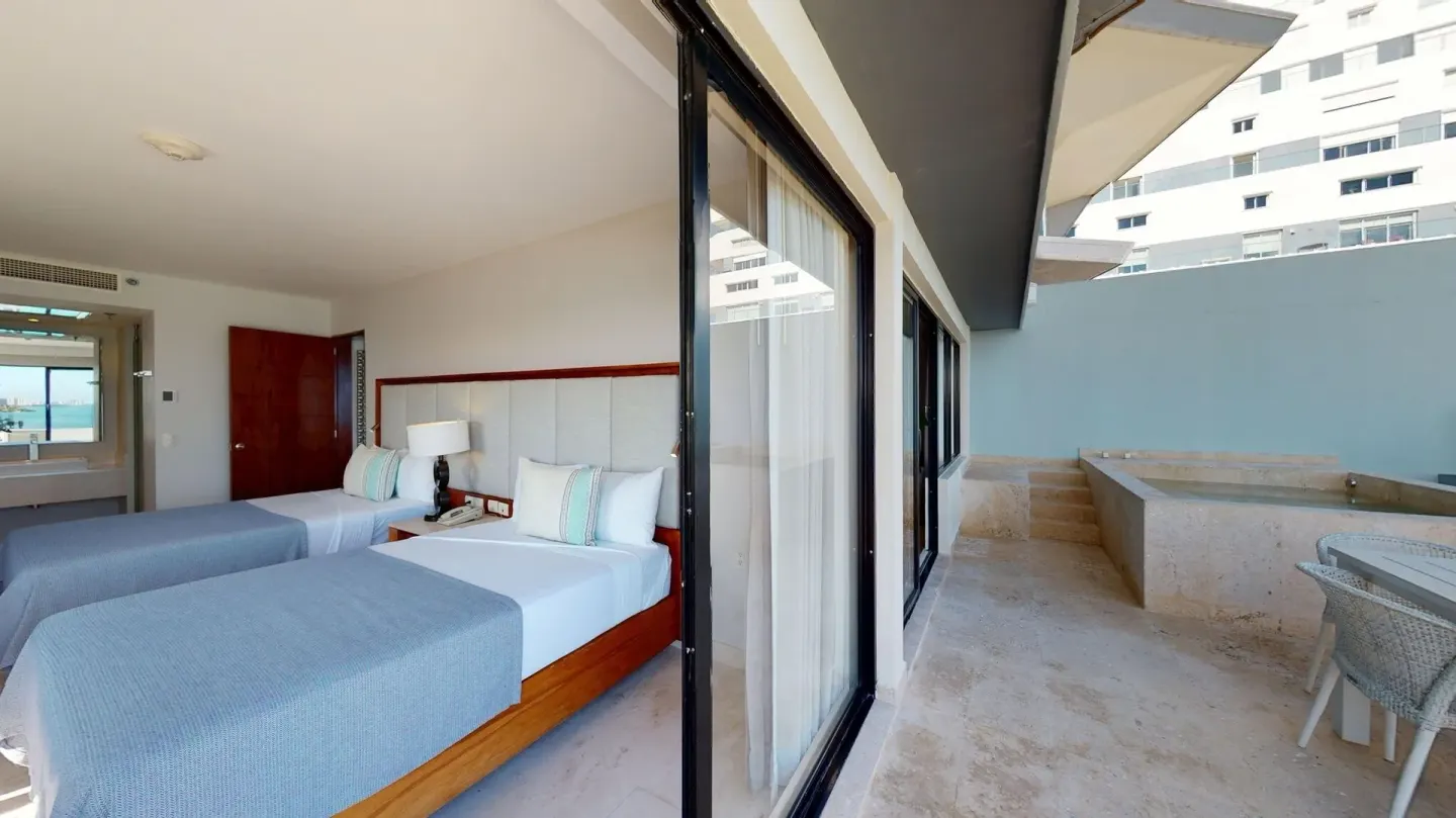 Guest room with two beds opening to a terrace at Park Royal Beach Cancun.